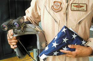 Air Force Reserve Master Sgt. Derek Bryant and two of his most valuable items -- his night-vision goggles and the American flag which he flew inside his C-17 aircraft. The flag has been with him in Afghanistan and Iraq.