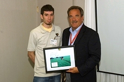 Brian Horn presents Dan Ryan a picture of himself with a Raytheon-built weapon in Iraq.